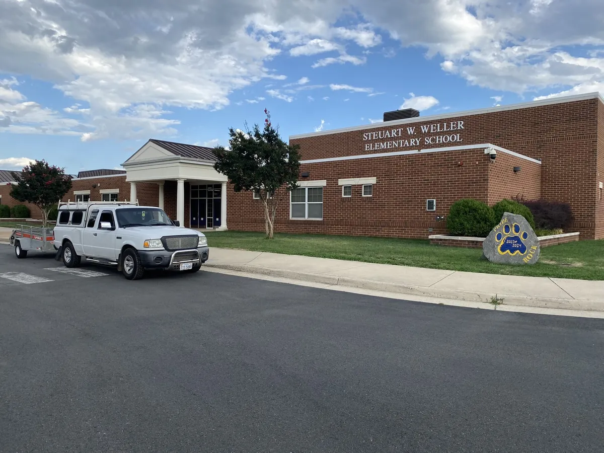 Green Leaves work truck at commercial property - school grounds maintenance